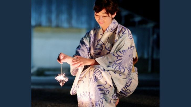 浴衣で線香花火をする女性